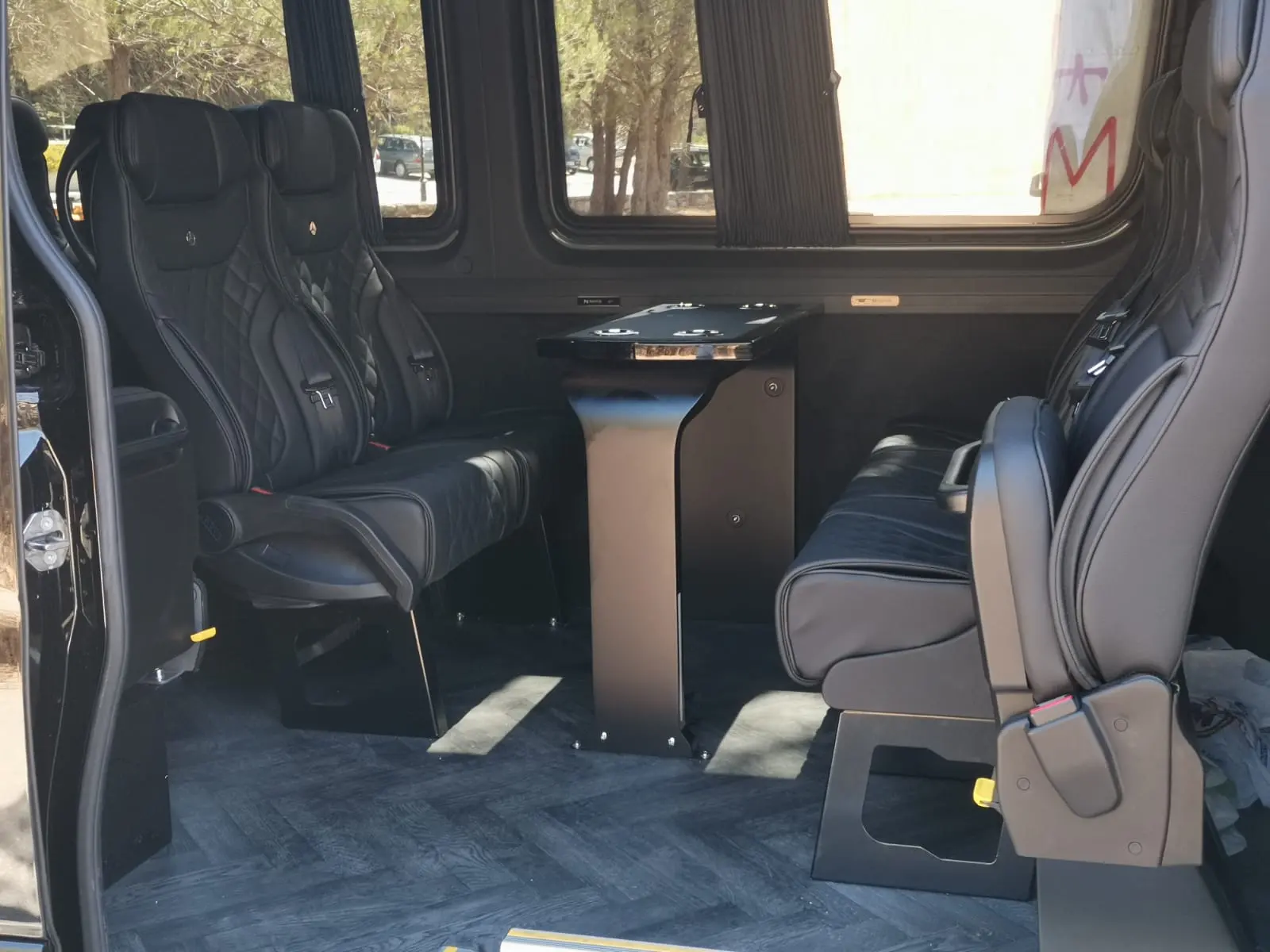 Quilted black leather seats and a folding table inside the mini bus cabin