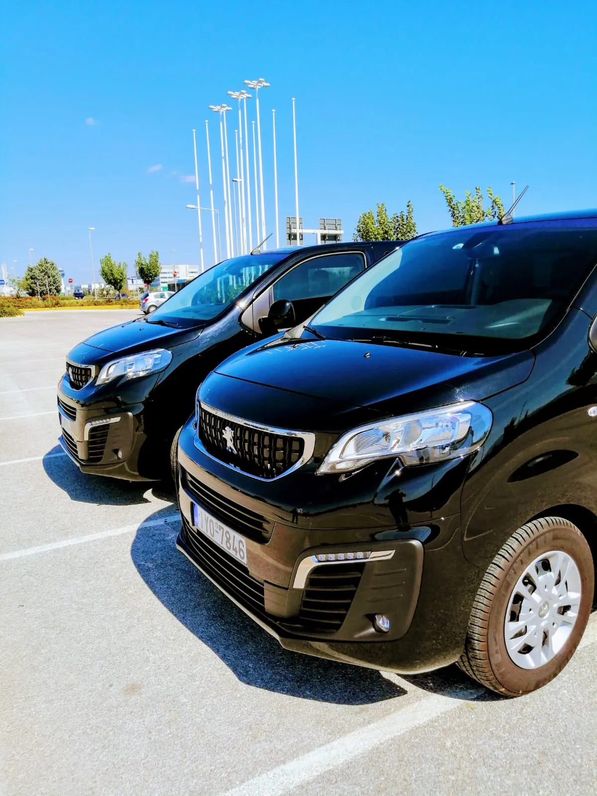 Δύο mini van Peugeot Traveller παρκαρισμένα δίπλα δίπλα στο αεροδρόμιο